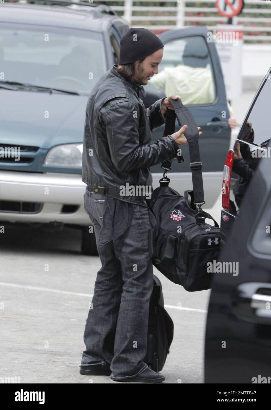 Taylor Kitsch schleppt seine eigenen Taschen auf dem Weg durch LAX, um einen Flug zu erwischen. Der X-Men Schauspieler trug eine Lederjacke und einen Hut, musste aber einige Schichten für die Sicherheitskontrolle ausziehen. Los Angeles, Ca. 6/2/09. Stockfoto