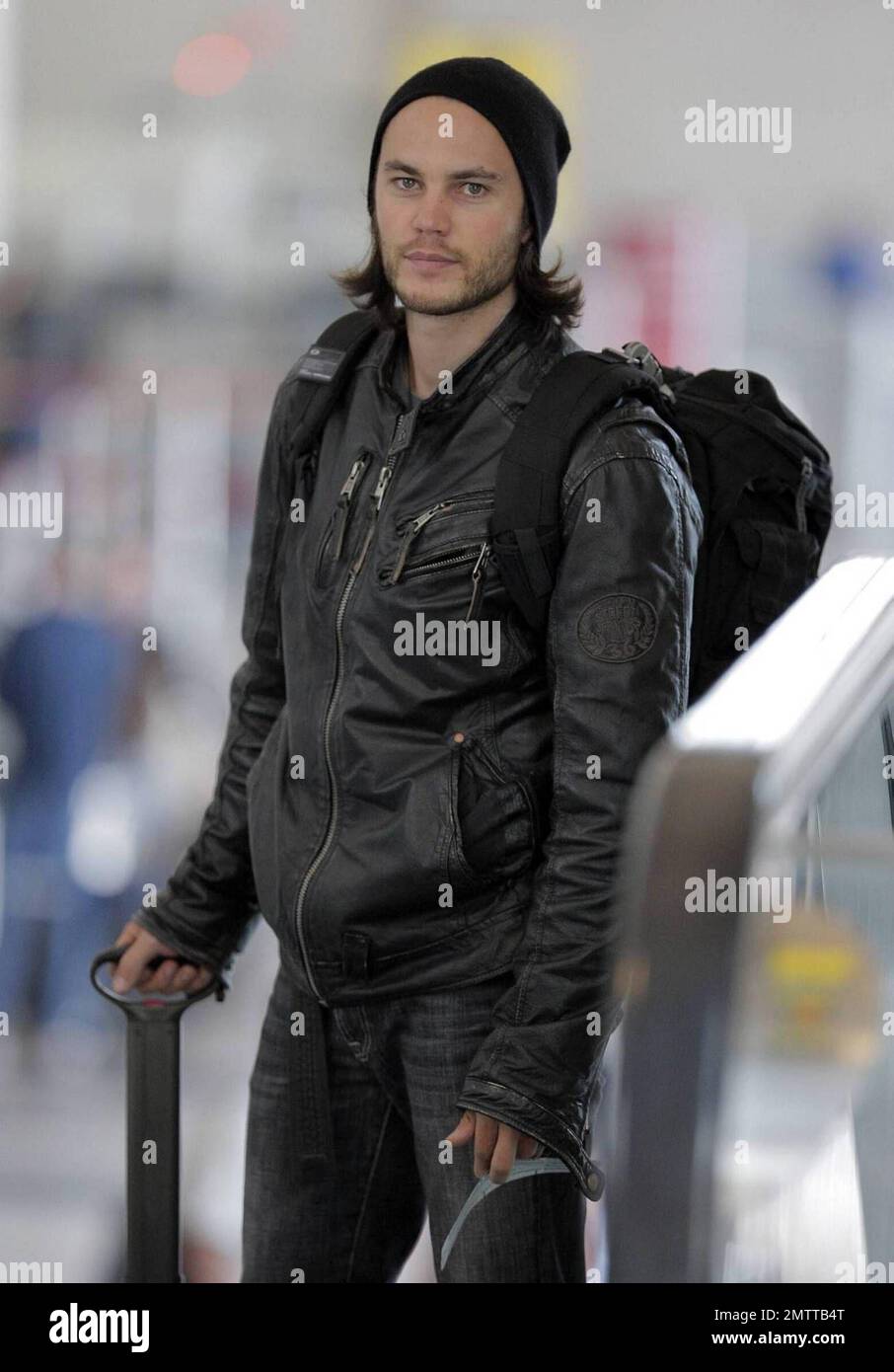 Taylor Kitsch schleppt seine eigenen Taschen auf dem Weg durch LAX, um einen Flug zu erwischen. Der X-Men Schauspieler trug eine Lederjacke und einen Hut, musste aber einige Schichten für die Sicherheitskontrolle ausziehen. Los Angeles, Ca. 6/2/09. Stockfoto