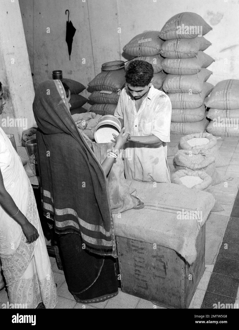 A woman receives her ration of rice at ration shop in India, Sept. 21 ...