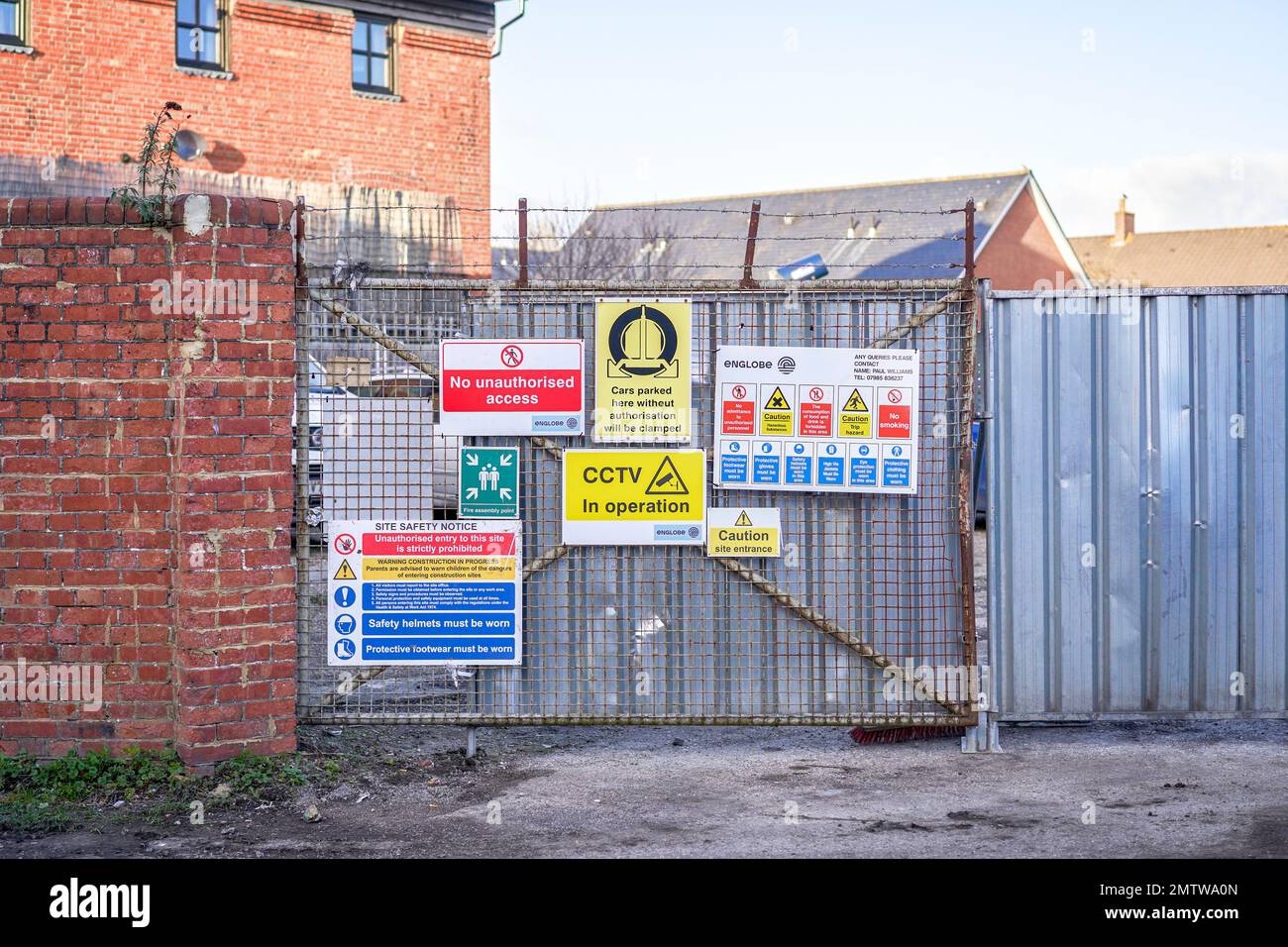 Warn- und Hinweisschilder an einem Tor am Eingang einer Baustelle Stockfoto