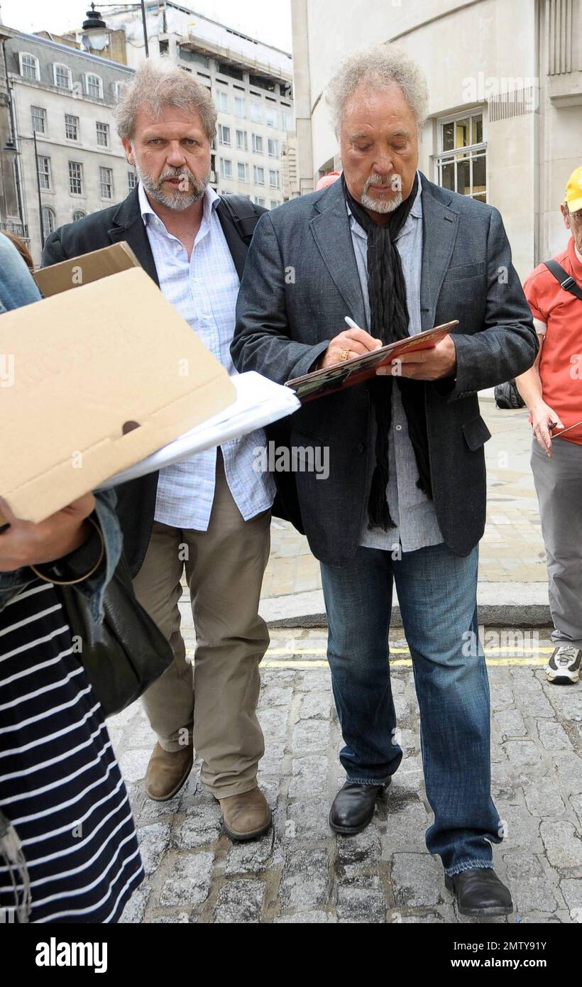 Der legendäre Sänger Sir Tom Jones, der letzten Monat 70 wurde, lächelt und posiert für Fotos, wenn er mit seinem Sohn und Manager Mark Woodward im BBC Broadcasting House ankommt. London, Großbritannien. 7/26/10. Stockfoto
