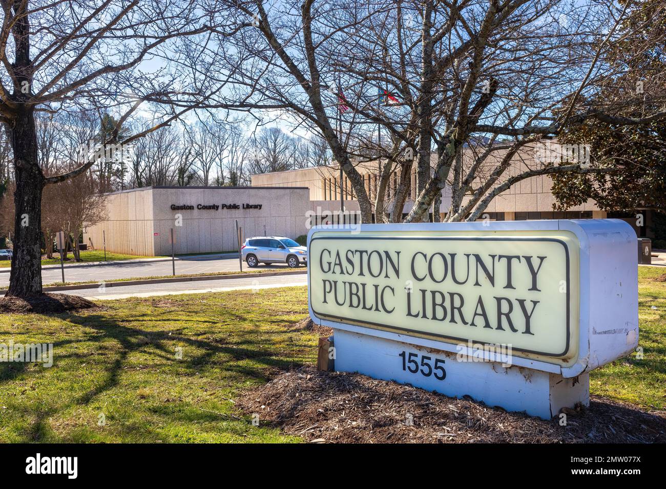 GASTONIA, NC-28 JAN 2023: Gaston County Public Library in Gastonia, Gebäude, Denkmalschild, Parkplatz. Sonniger, blauer Himmel. Stockfoto