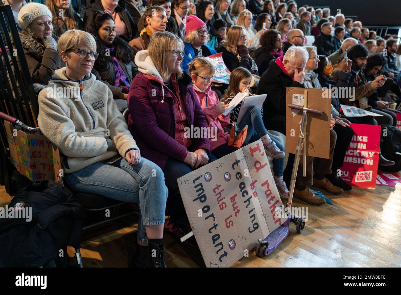 Exeter, England, 01. Februar 2023, eine Frau im Publikum der Corn Exchange hält ein Banner mit der Aufschrift "IÕd lieber unterrichten, aber das ist wichtig". Sie war eine von Hunderten von Menschen, die am Ende einer kurzen Kundgebung in Exeter Reden zuhörten. Mehrere hunderttausend Menschen streikten, um gegen Löhne und andere Beschäftigungsrechte zu protestieren. Die Union für öffentliche und kommerzielle Dienstleistungen hatte mit rund 100.000 Streikenden die zweithöchste Zahl von Personen, die an der Arbeitskampagne teilnahmen. Einige ihrer Mitglieder konnten nicht öffentlich streiken, da auch Schulen aufgrund des Streiks von teachersÕ geschlossen wurden Stockfoto