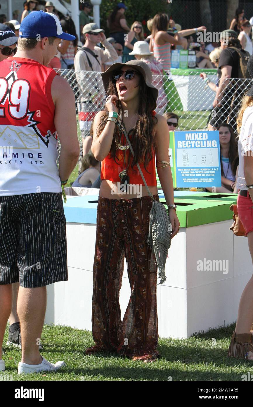 Die Schauspielerin Vanessa Hudgens flirtet am ersten Tag des Coachella Music and Arts Festivals auf den Empire Polo Fields mit einem geheimnisvollen Mann, gekleidet in Hippie-inspirierter Kleidung, einem großen Floppy-Hut und vielen Silberringen. Vanessa saß später mit Freunden herum und nippte an einem Getränk, das sie später zu recyceln schien. Indio, Kalifornien. 04/15/11. Stockfoto