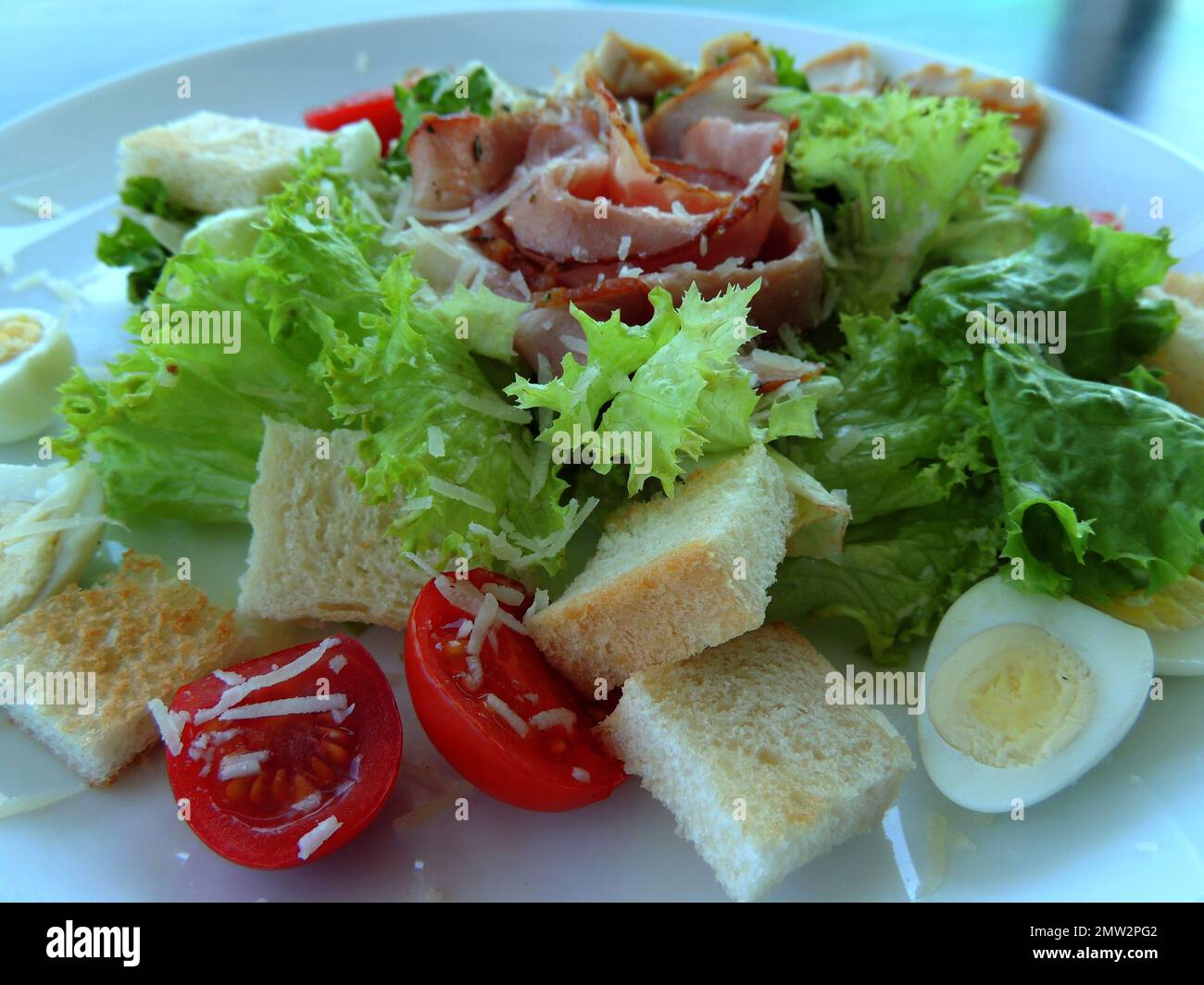 Teller mit Fleischsalat, serviert mit Toast, Tomaten und geriebenem Käse auf einem weißen Teller, detailliertes High-Resolution Foto Stockfoto