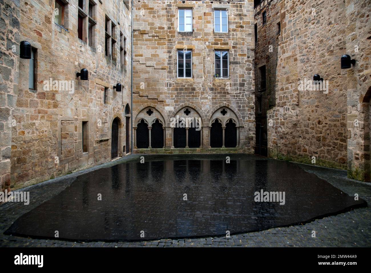 Ein riesiges Exemplar des Rosetta-Steins von Joseph Kosuth in Figeac, Frankreich, am Fuße des Geburtsorts von Jean-Francois Champollion in Figeac in der Lot-Abteilung, ist der Ort des Schreibens. Auf dem Boden liegt eine riesige Scheibe schwarzen Granits, die den Erlass zu Ehren des pharaos Ptolemäus gegen Epiphanes im Jahre 196 v. Chr. auf dem Place des ecritures in Figeac, Frankreich, am 31. Januar 2023 reproduziert. Der Rosetta-Stein ist eine Stele aus Granodiorit, die in drei Versionen eines Dekrets eingeprägt ist, das 196 v. Chr. in Memphis, Ägypten, während der ptolemäischen Dynastie im Namen von König Ptolemäus V Epiphanes erlassen wurde. Der obere und der mi Stockfoto