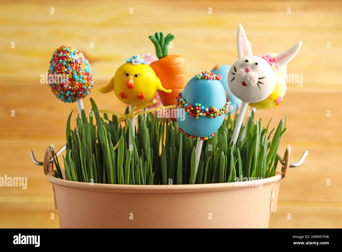 Leckerer süßer Kuchen, der in einen Eimer mit Gras fällt. Osterferien Stockfoto