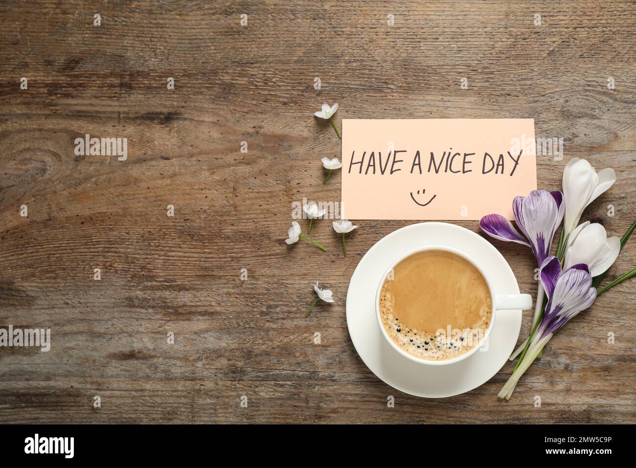 Morgenkaffee, Blumen und Karte mit EINEM SCHÖNEN TAGESWUNSCH auf einem Holztisch, flach liegend. Platz für Text Stockfoto