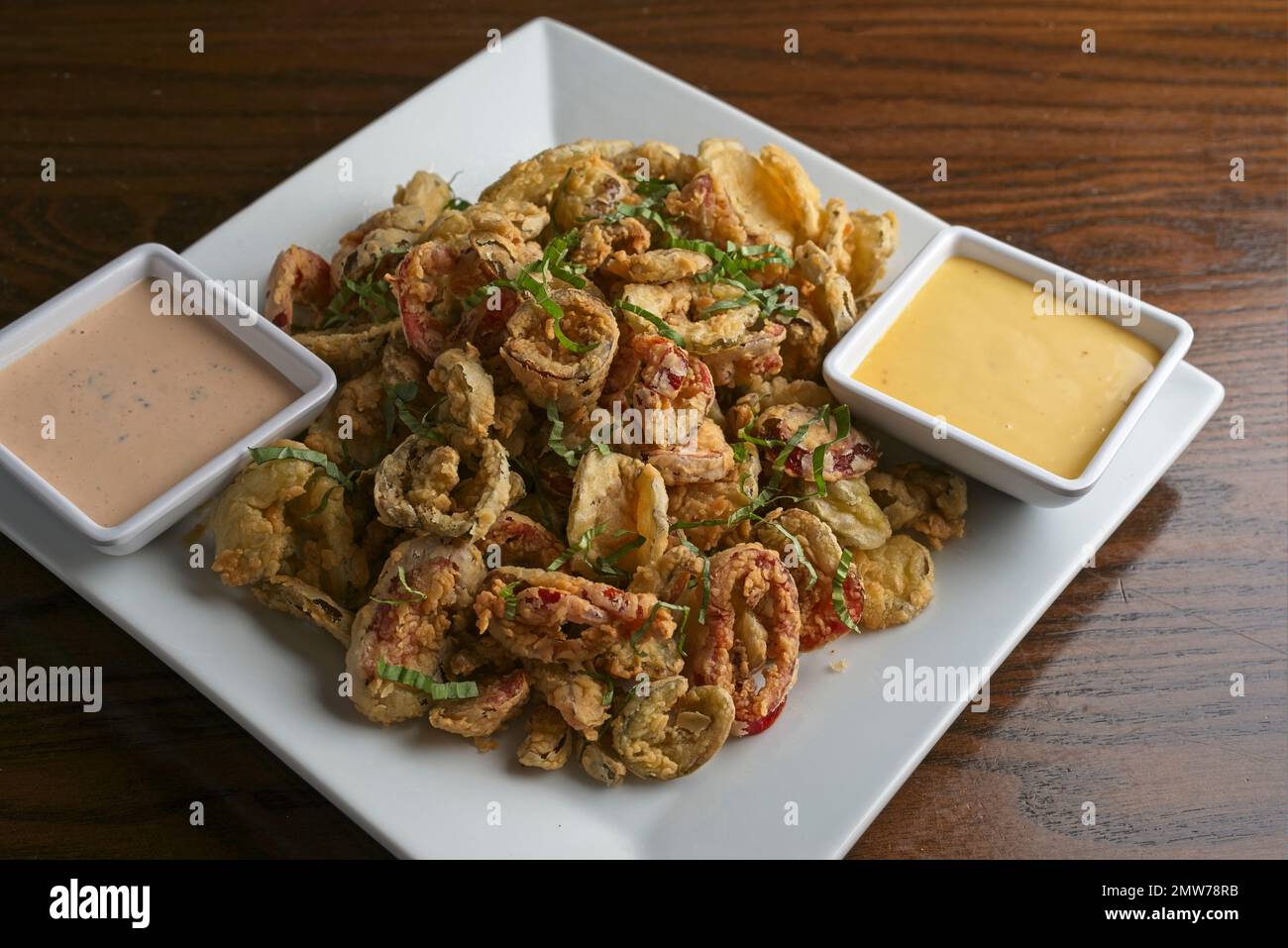 Knusprige gebratene Calamari mit frischem Basilikum und Sriracha Ranch und Honigsenfsoßen Stockfoto