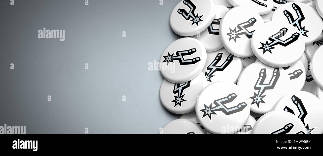 Logos des American-NBA-Basketballteams San Antonio Spurs auf einem Haufen auf einem Tisch. Stockfoto