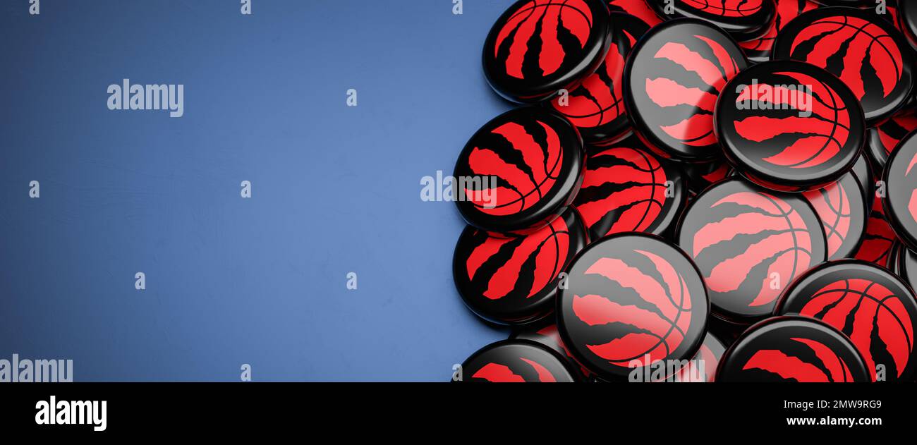 Logos des American-NBA-Basketball-Teams Toronto Raptors auf einem Haufen auf einem Tisch. Stockfoto