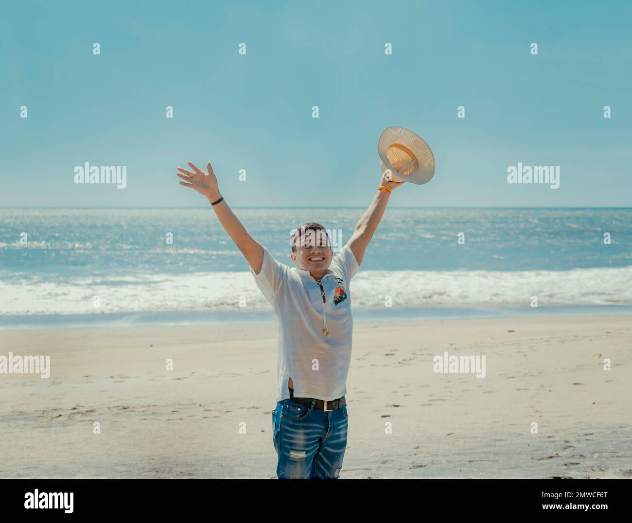 Glücklicher gutaussehender Mann im Urlaub im Freien, glücklicher junger lateinischer Mann am Strand, Touristenreisen Stockfoto