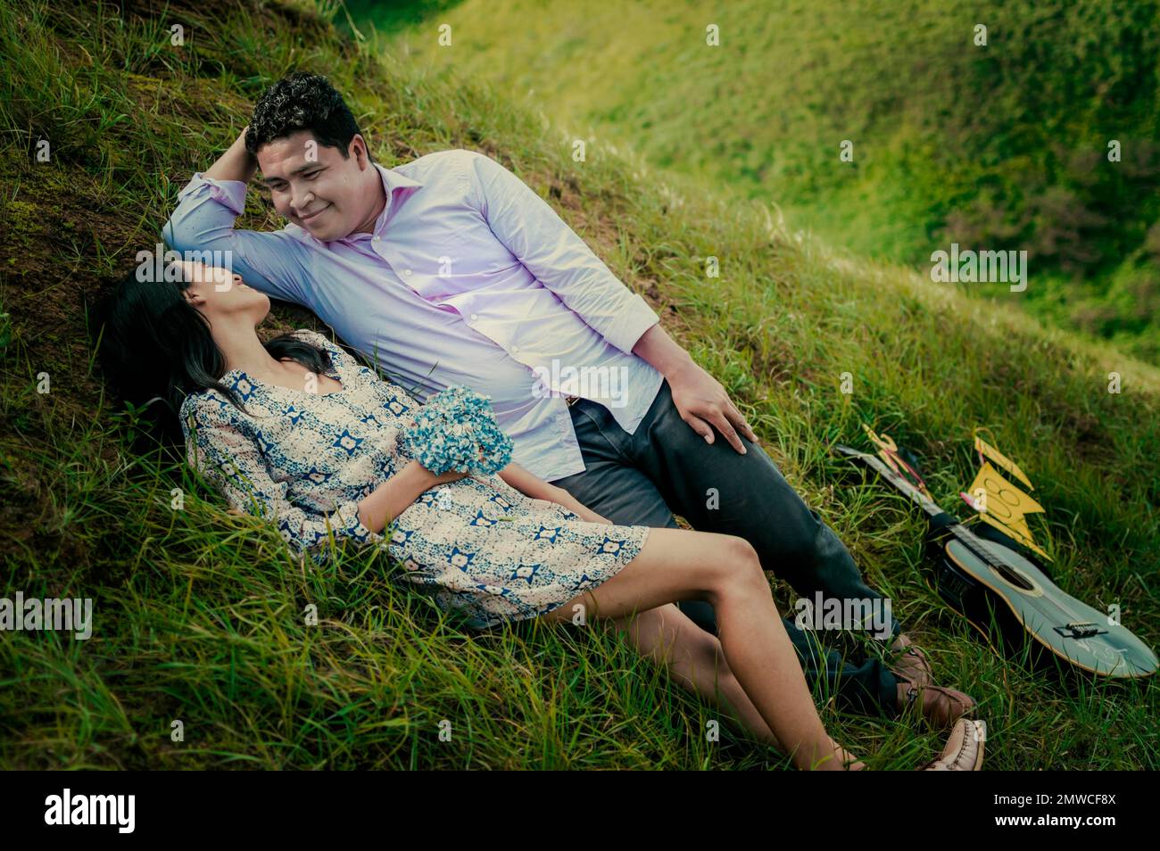 Hochzeitspaar liegt auf dem Gras, Paar liegt auf dem Gras, Liebes Stockfoto