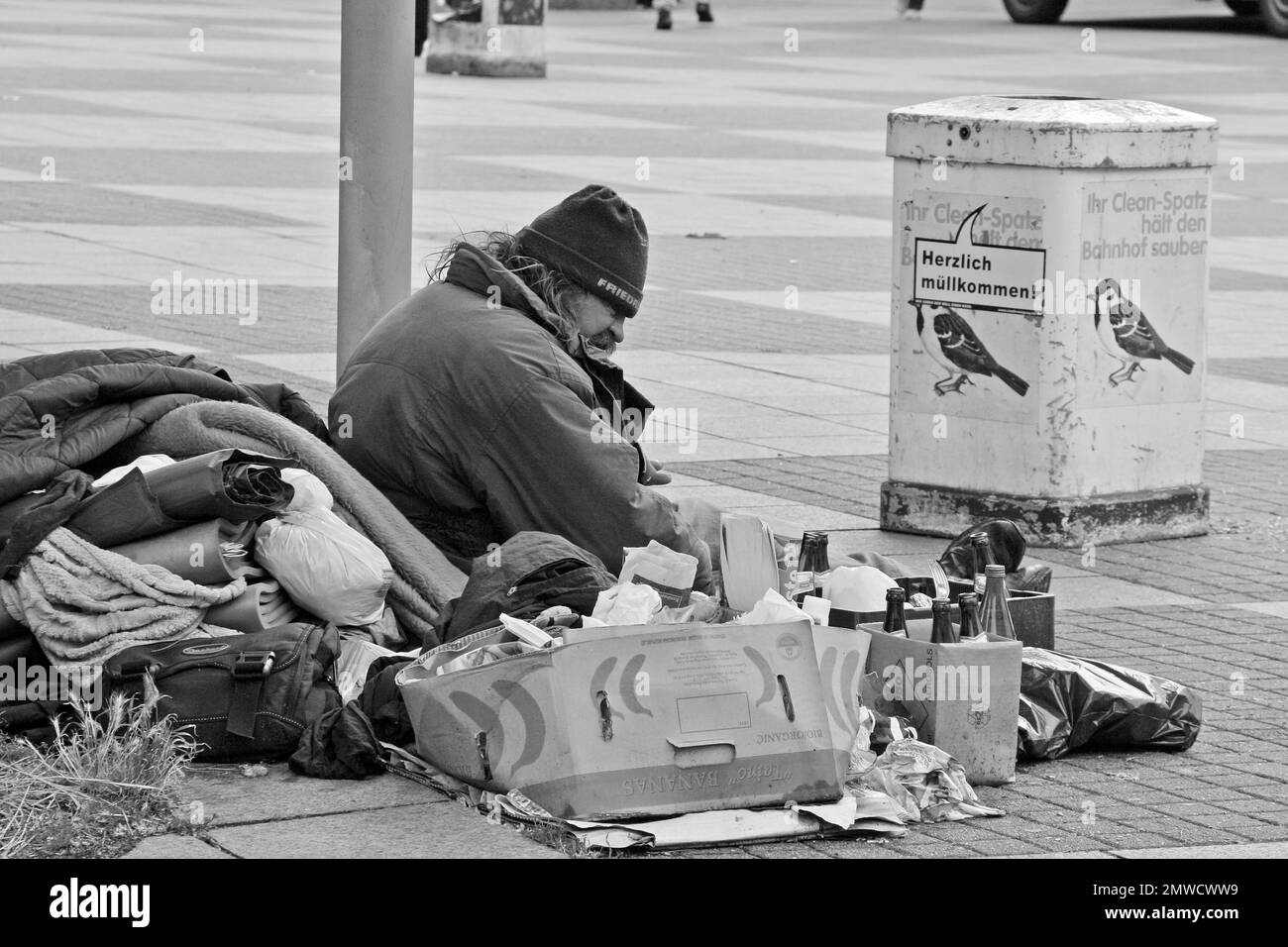 Ein Obdachloser, der mit seinen Sachen auf der Straße sitzt, Hamburg, Deutschland Stockfoto
