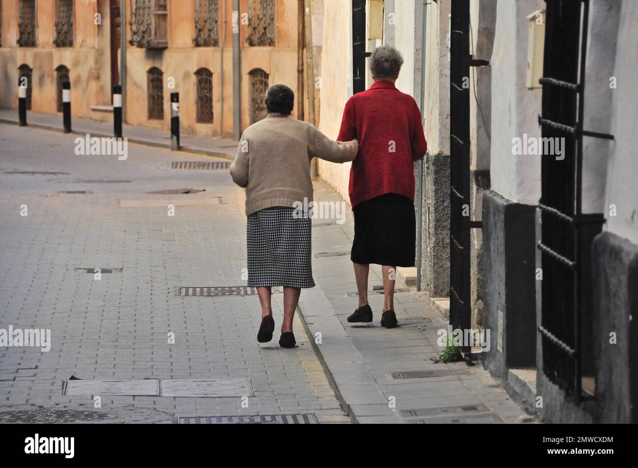 Zwei alte Frauen lehnten sich beim Gehen auf den Bürgersteig, Spanien Stockfoto
