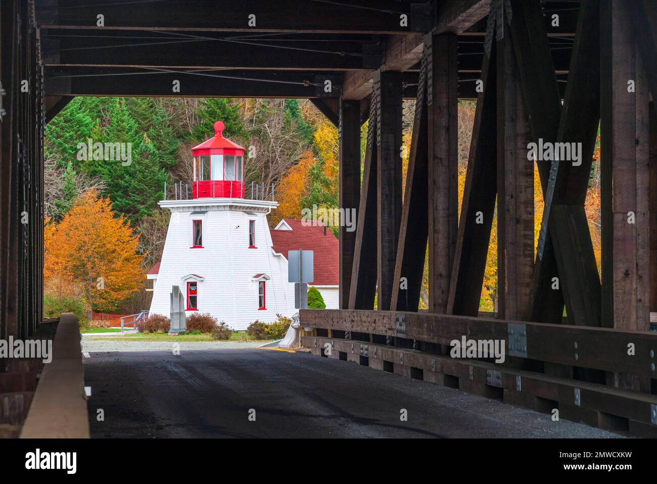 Der Leuchtturm, eingerahmt von einer überdachten Brücke in St. Martins, New Brunswick, Kanada. Stockfoto