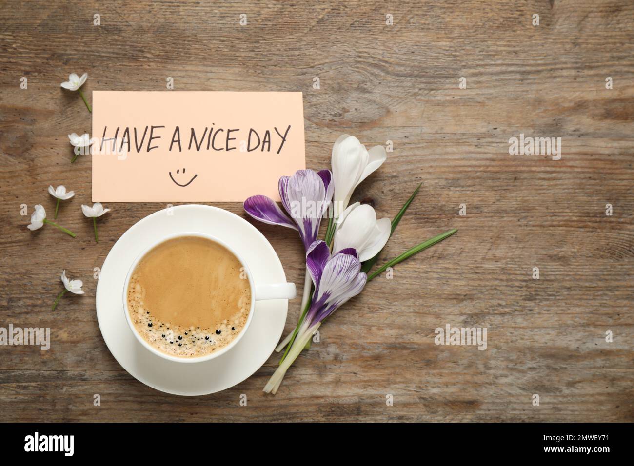 Morgenkaffee, Blumen und Karte mit EINEM SCHÖNEN TAGESWUNSCH auf einem Holztisch, flach liegend. Platz für Text Stockfoto