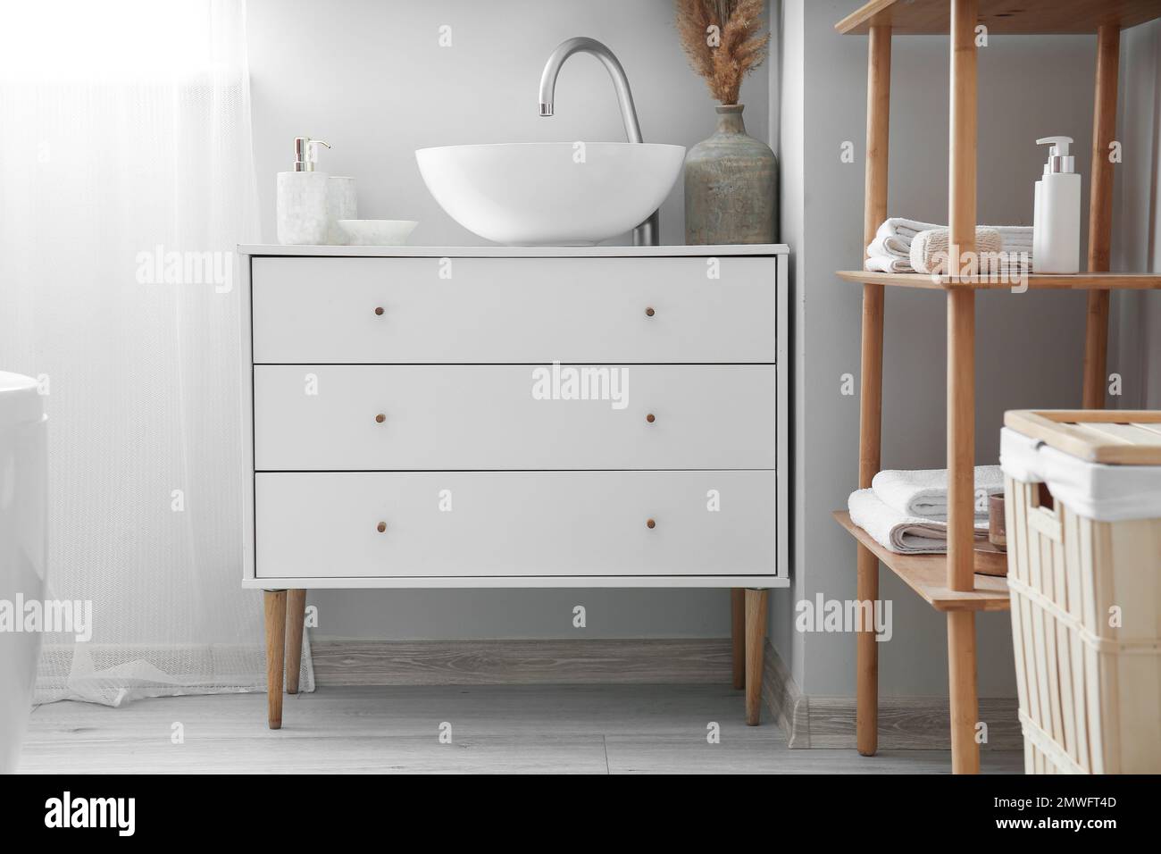 Kommode mit Waschbecken und Vase im hellen Badezimmer Stockfotografie -  Alamy