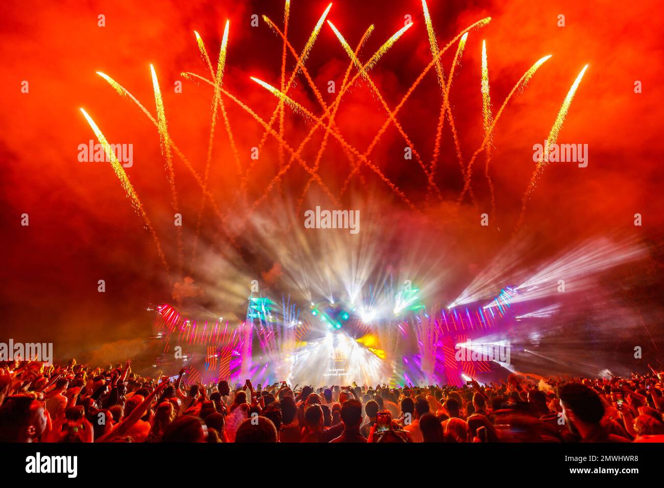 Die hell beleuchtete Bühne mit Feuerwerk hinter dem Publikum während des Musikfestivals Latin Village Stockfoto