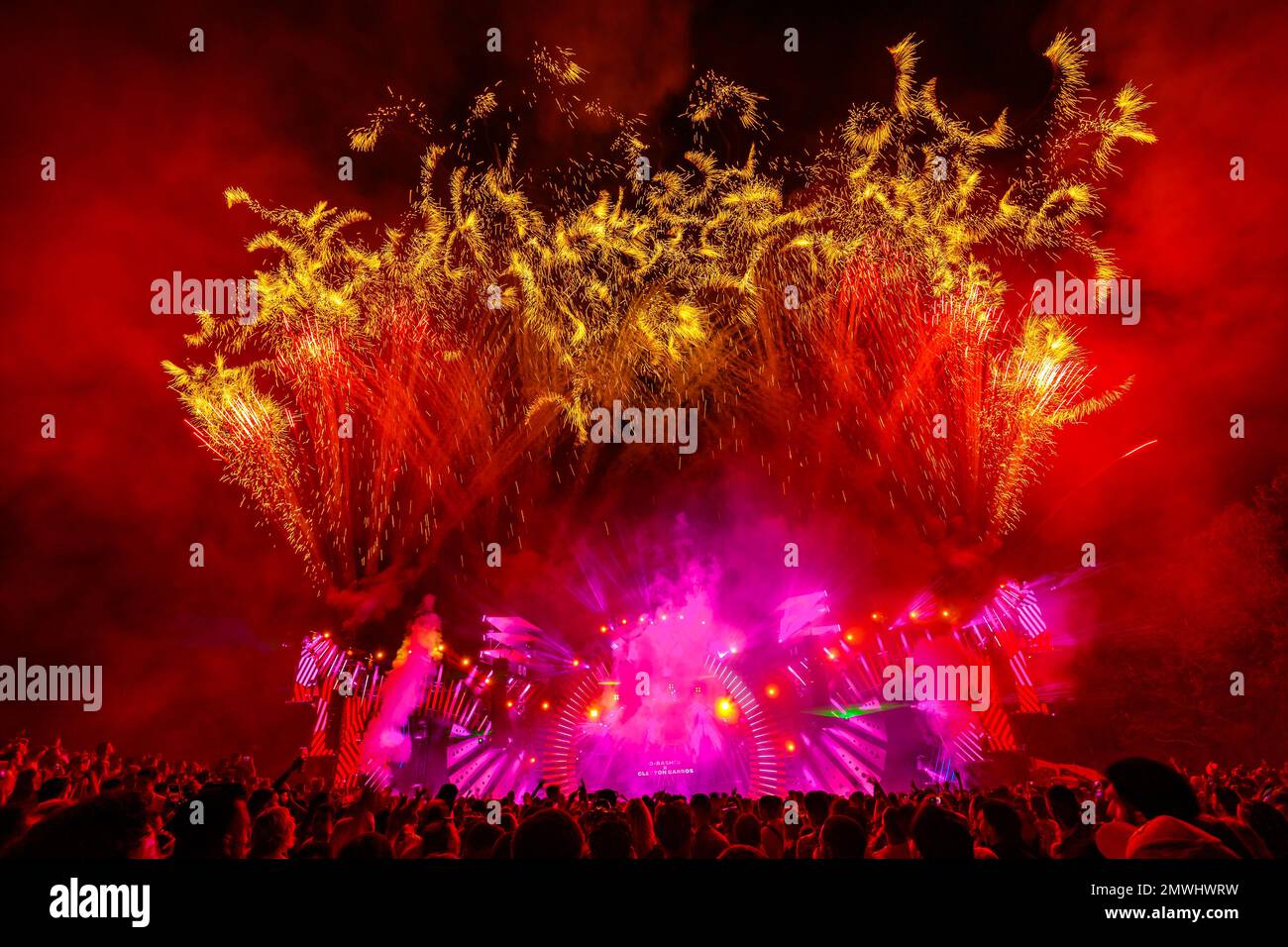 Die hell beleuchtete Bühne mit Feuerwerk hinter dem Publikum während des Musikfestivals Latin Village Stockfoto