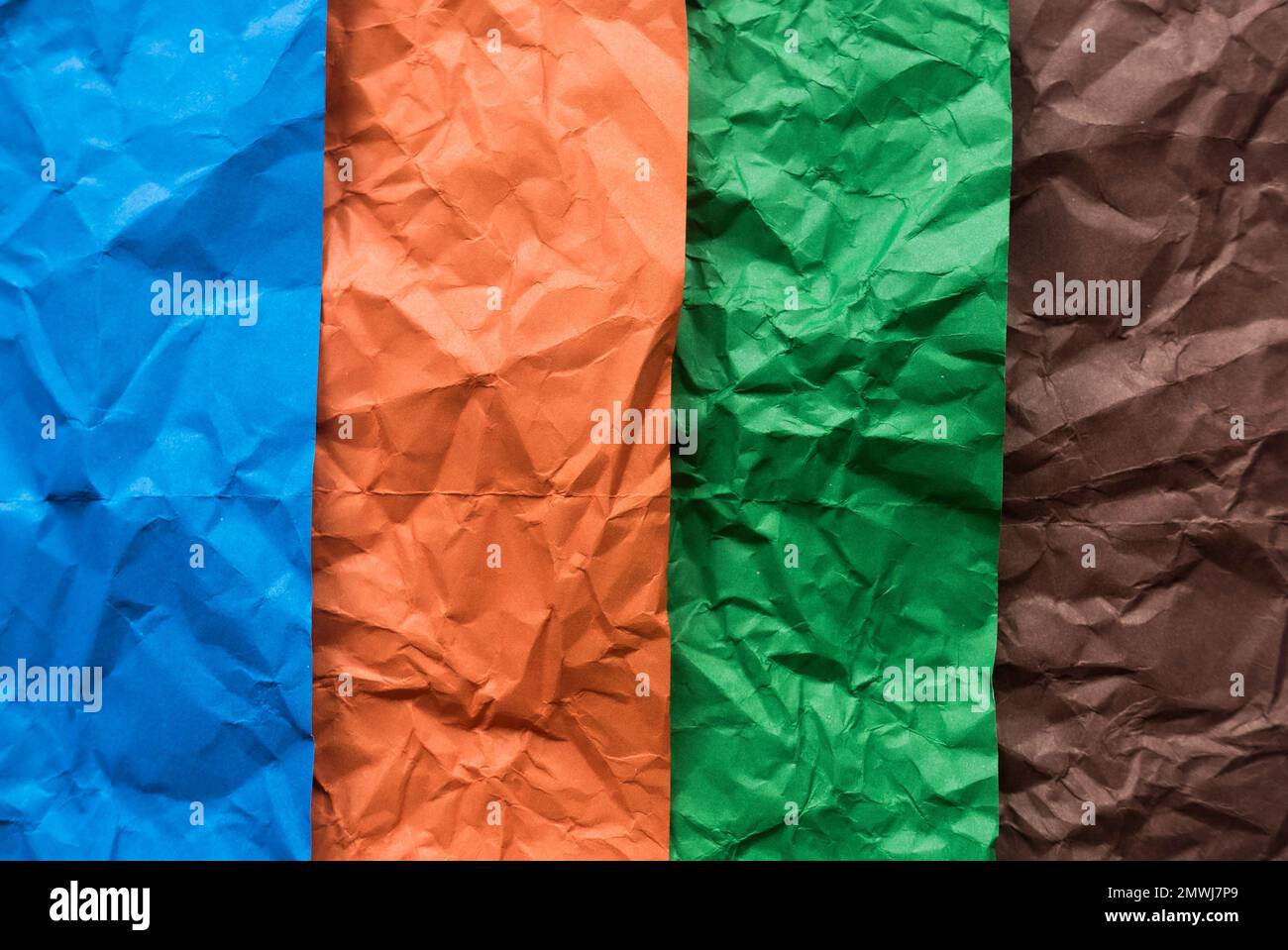 Blau, Orange, Grün und Braun zerknittertes Papier als Hintergrund. Stockfoto