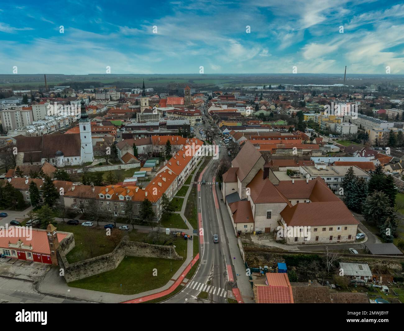 Blick aus der Vogelperspektive auf die mittelalterliche Burg Pezinok (Bazin) mit restauriertem roten Dach und mittelalterlichem Zentrum des Weinhandels mit gotischer Kirche und Spuren der Stadtmauer Stockfoto