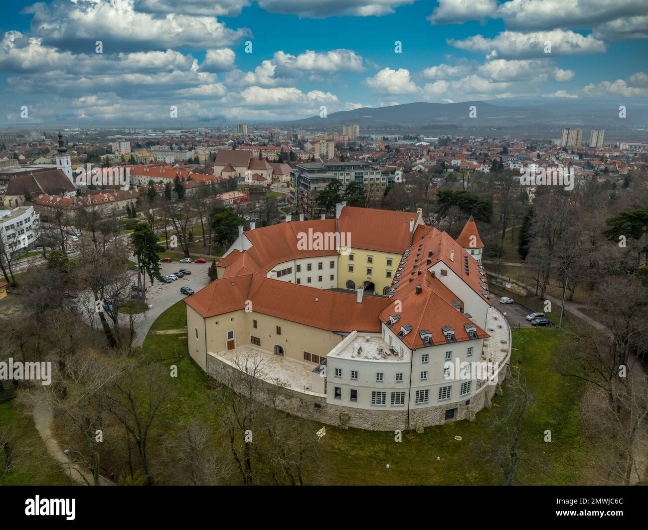 Blick aus der Vogelperspektive auf die mittelalterliche Burg Pezinok (Bazin) mit restauriertem roten Dach und mittelalterlichem Zentrum des Weinhandels mit gotischer Kirche und Spuren der Stadtmauer Stockfoto