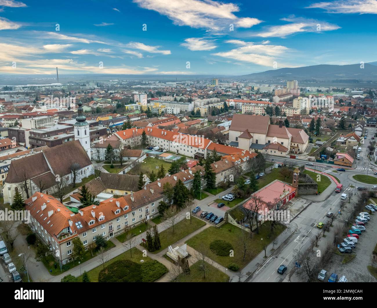 Blick aus der Vogelperspektive auf die mittelalterliche Burg Pezinok (Bazin) mit restauriertem roten Dach und mittelalterlichem Zentrum des Weinhandels mit gotischer Kirche und Spuren der Stadtmauer Stockfoto