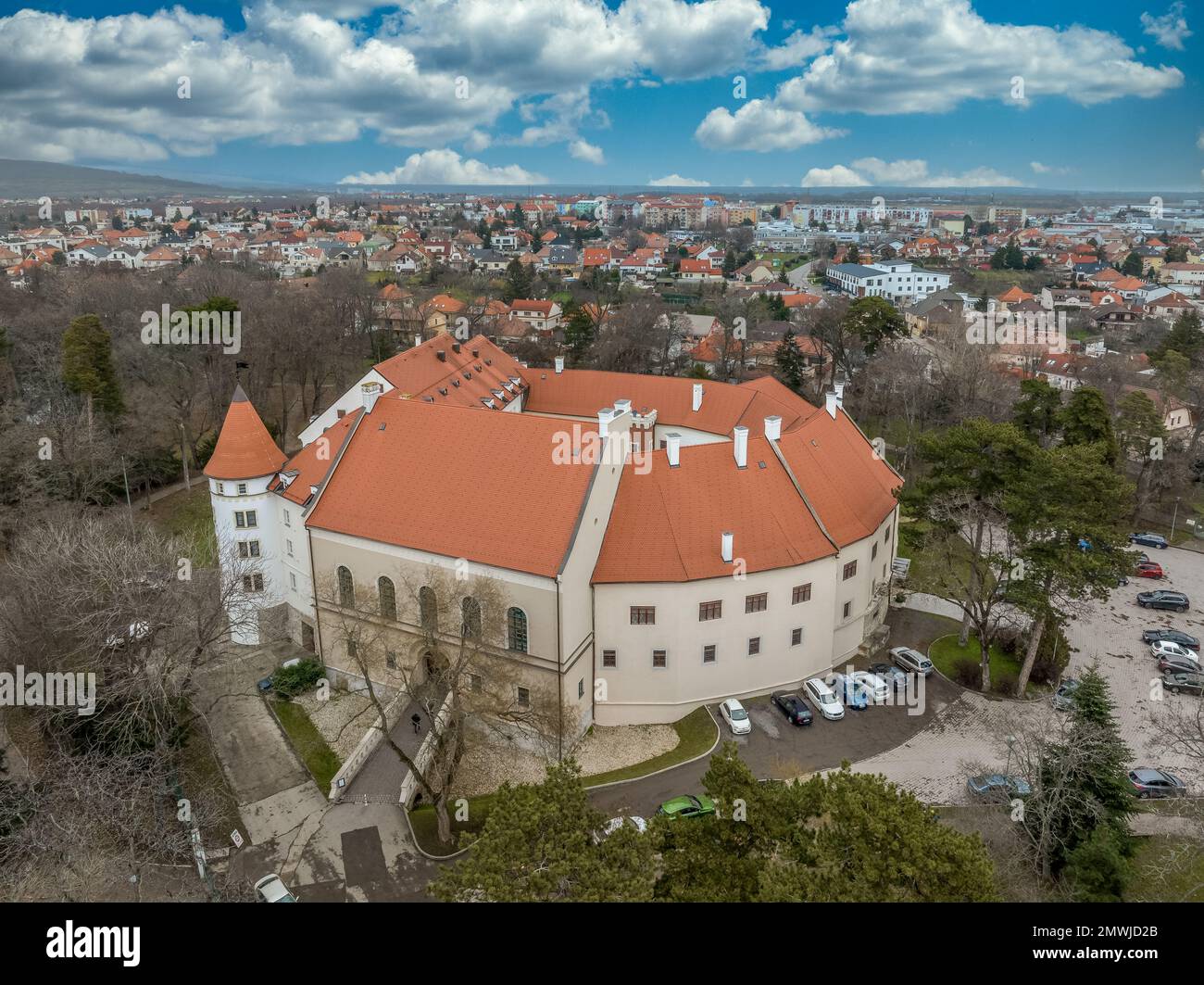Blick aus der Vogelperspektive auf die mittelalterliche Burg Pezinok (Bazin) mit restauriertem roten Dach und mittelalterlichem Zentrum des Weinhandels mit gotischer Kirche und Spuren der Stadtmauer Stockfoto