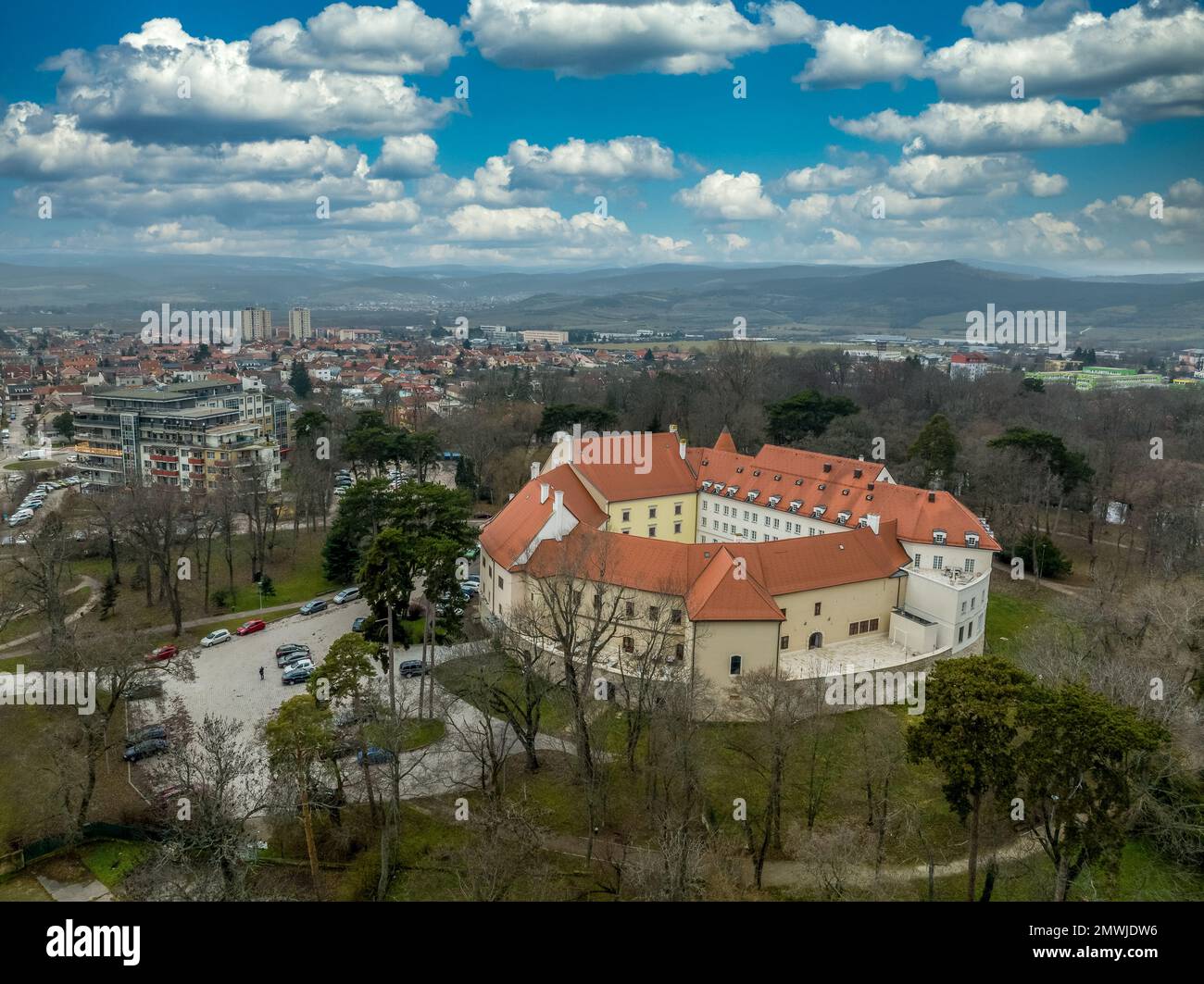 Blick aus der Vogelperspektive auf die mittelalterliche Burg Pezinok (Bazin) mit restauriertem roten Dach und mittelalterlichem Zentrum des Weinhandels mit gotischer Kirche und Spuren der Stadtmauer Stockfoto
