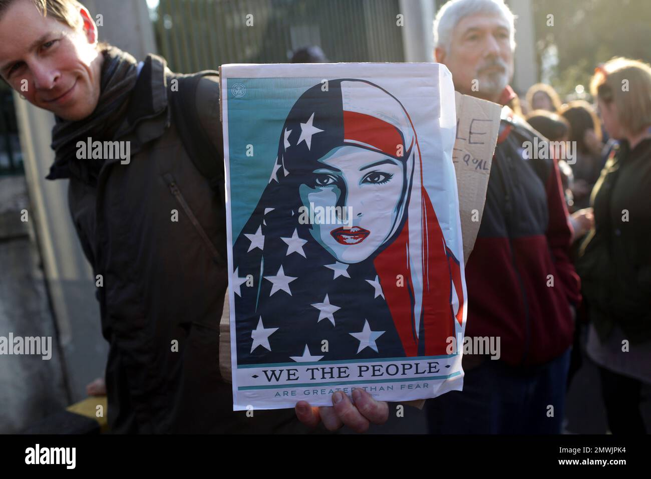 A demonstrator holds a poster outside the U.S. embassy, in the background, during a Women's March Saturday, Jan. 21, 2017, in Lisbon. The march is part of a worldwide day of actions following the inauguration of U.S. President Donald Trump. (AP Photo/Armando Franca) Stockfoto