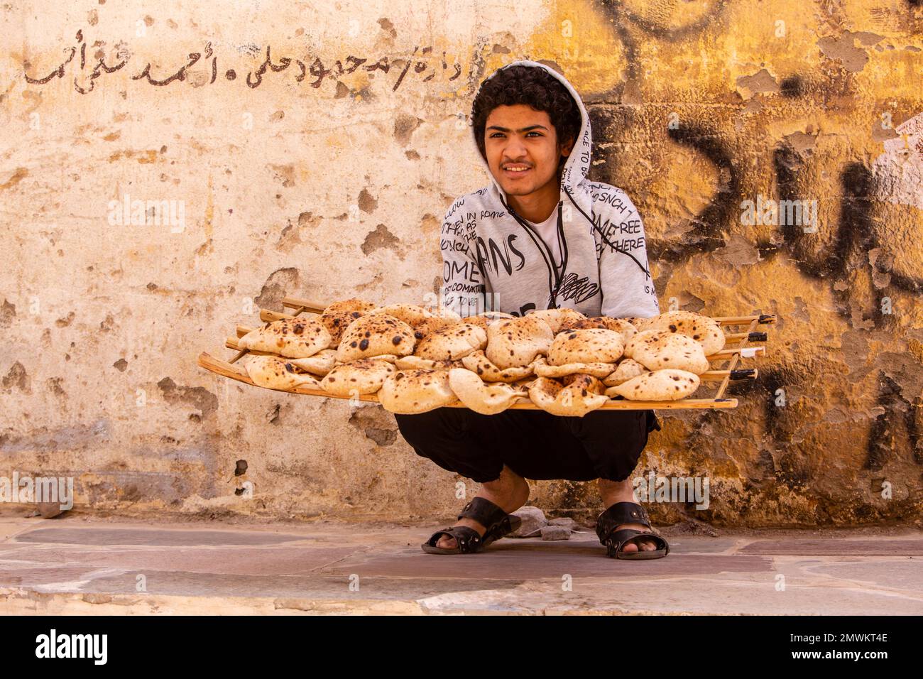 Ein Junge, der frisch gebackenes Brot in Assuan Old Souks, Assuan, Ägypten, verkauft Stockfoto