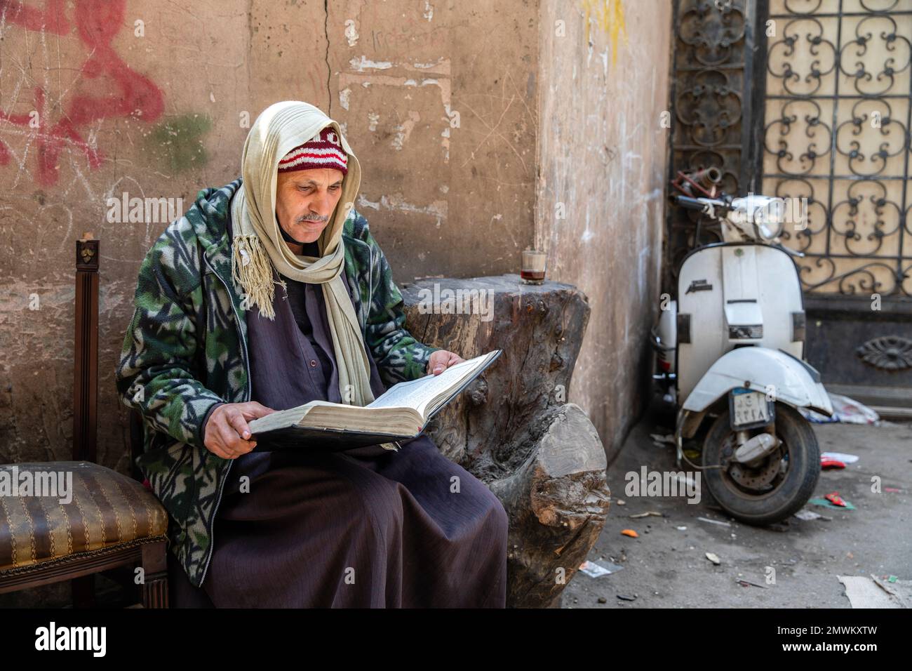 Koptischer Priester liest Bibel in den Straßen von Zabbaleen (Müll) City, Kairo, Ägypten Stockfoto