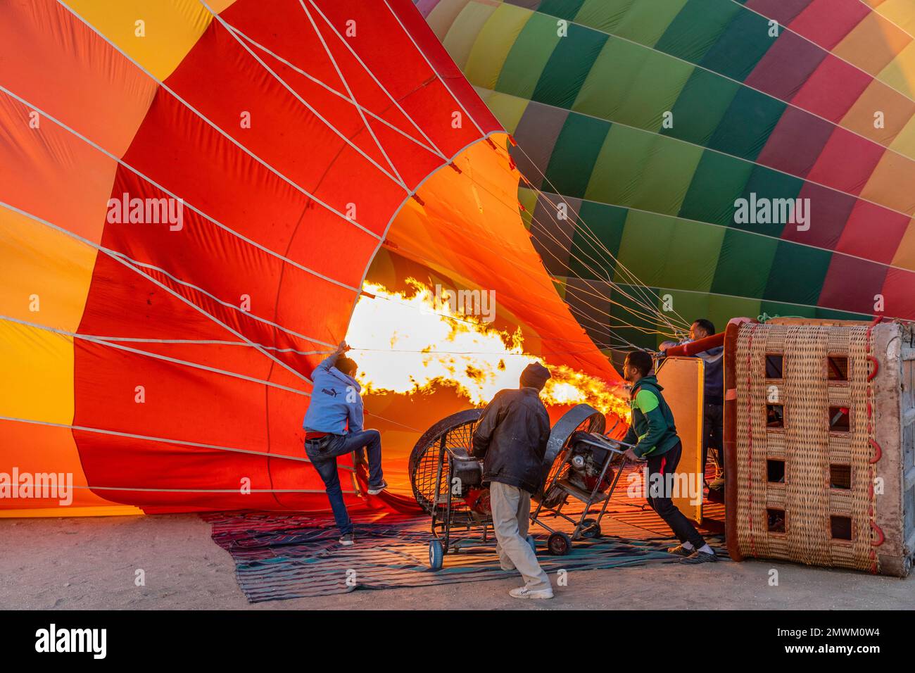 Crews benutzen Fans, um Heißluftballons entlang des Nils in Luxor, Ägypten, aufzublasen Stockfoto