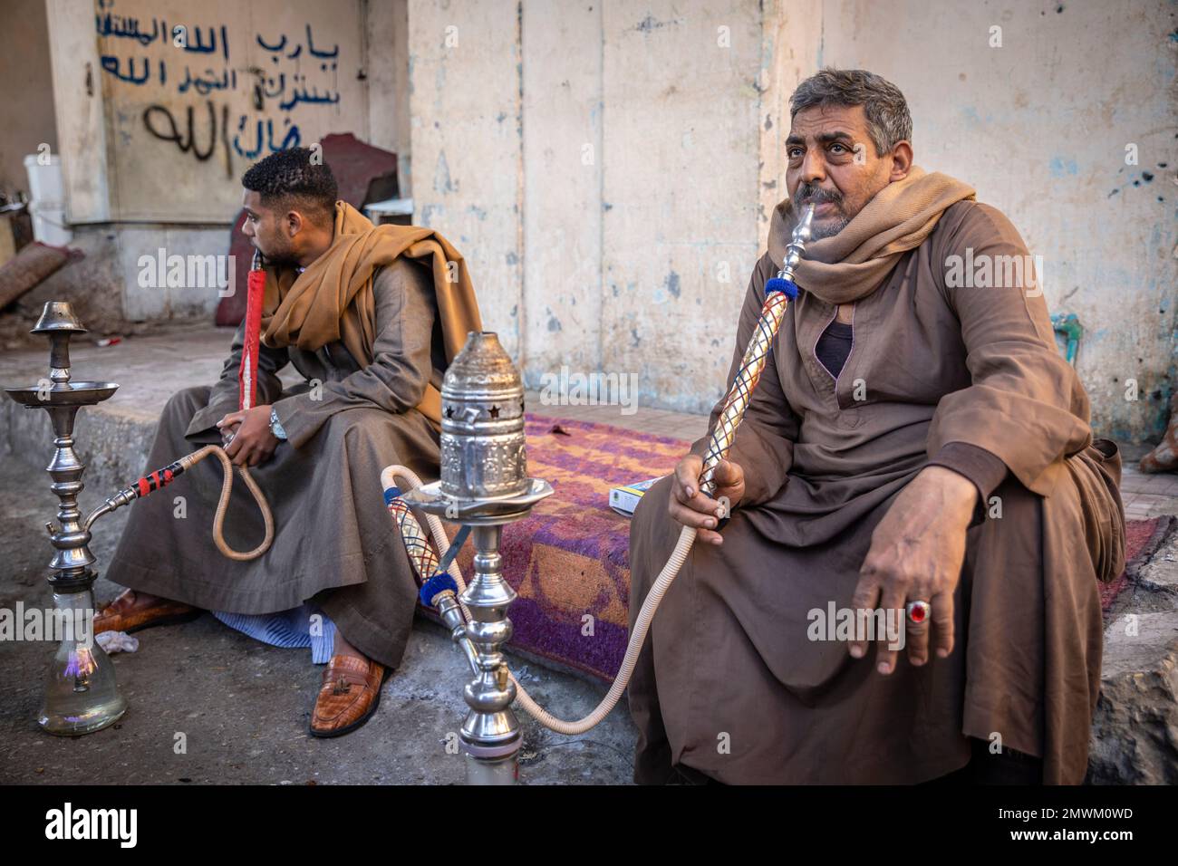 Ägyptische Männer, die in den Straßen von Luxor, Ägypten, Shisha rauchen Stockfoto