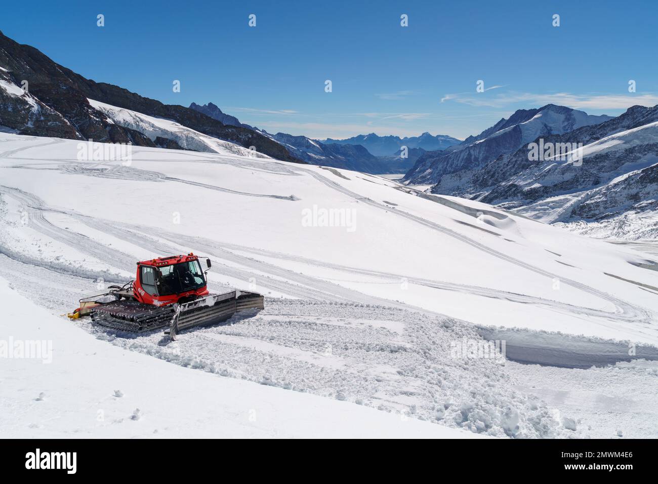 Am Jungfraujoch in der Schweiz bewegt sich ein riesiger roter Schneepflug entlang der Gletscheroberfläche Stockfoto