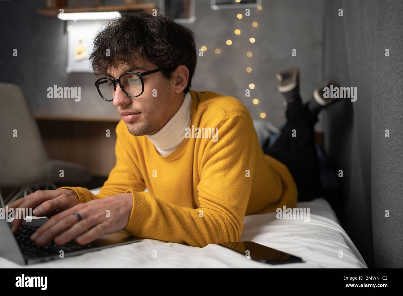 College-Student, der von zu Hause in seinem Zimmer studiert. Studentenwohnheim. Speicherplatz kopieren Stockfoto