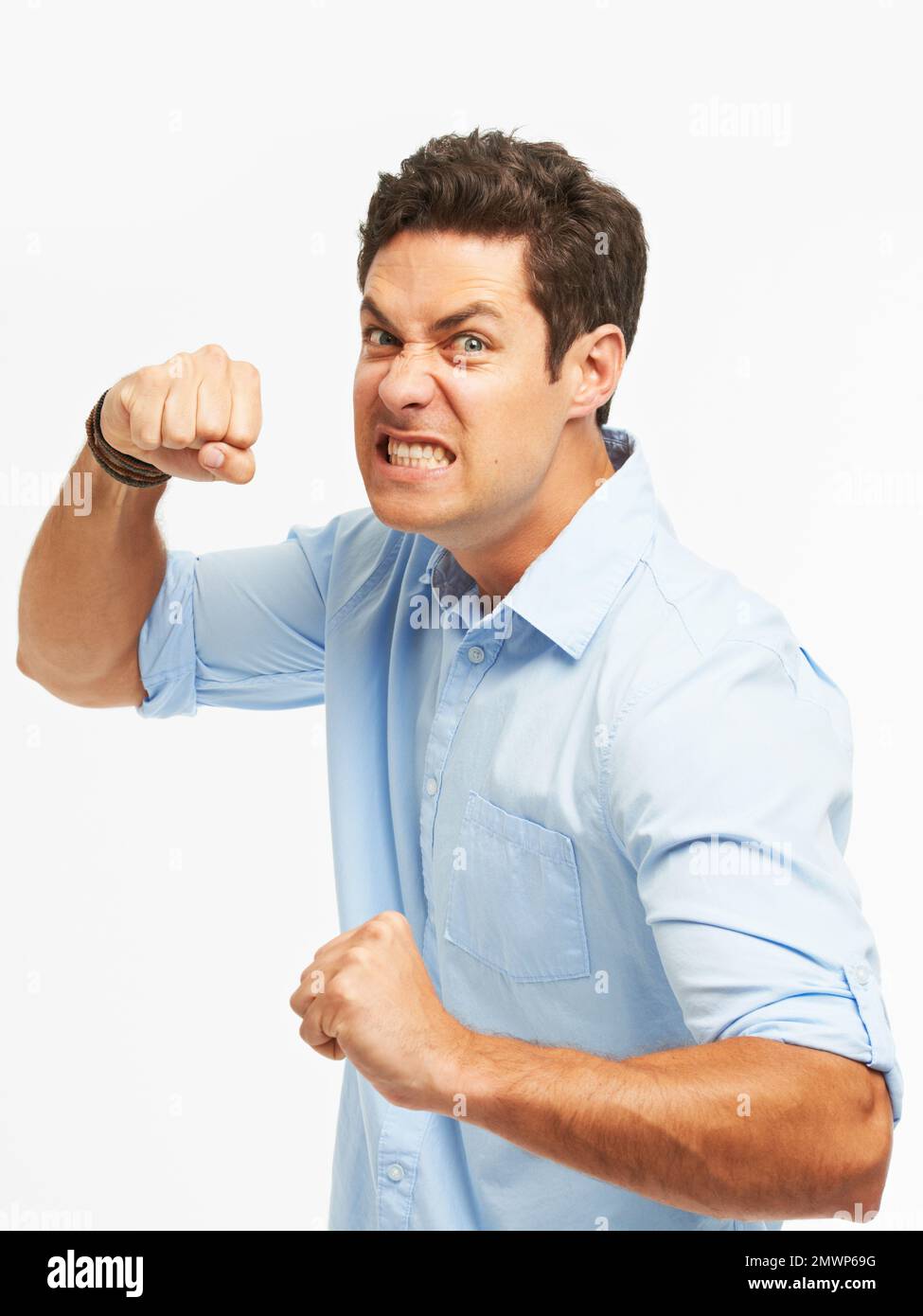 Er verliert die Nerven. Ein wütender junger Mann mit geballten Fäusten, bereit zu schlagen, vor weißem Hintergrund. Stockfoto