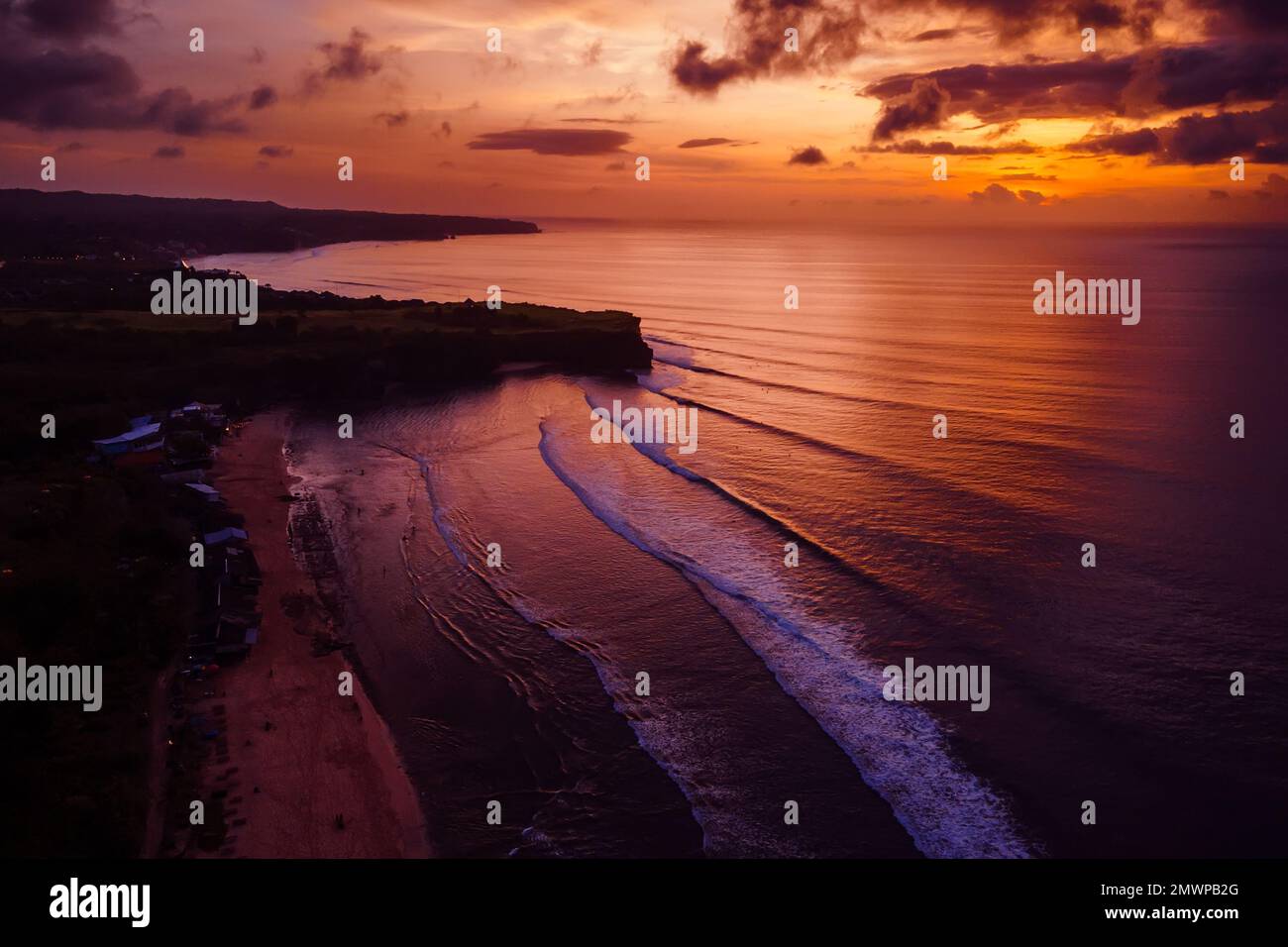 Luftaufnahme des farbenfrohen Sonnenuntergangs oder Sonnenaufgangs und des Ozeans mit Wellen auf Bali. Stockfoto