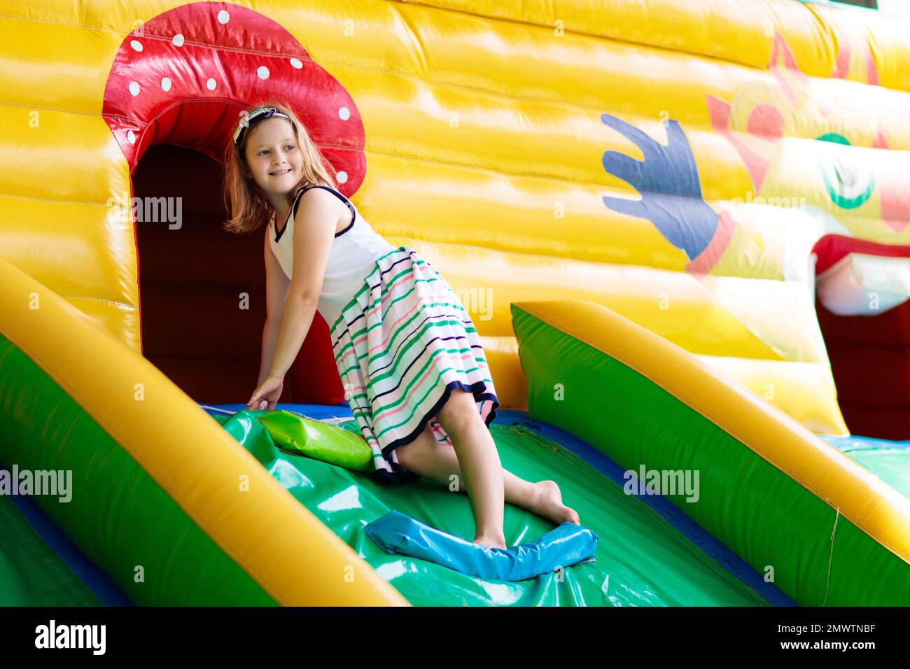 Kinder springen auf buntem Spielplatz-Trampolin. Kinder springen in aufblasbare Sprungburg auf Kindergarten Geburtstagsparty Stockfoto