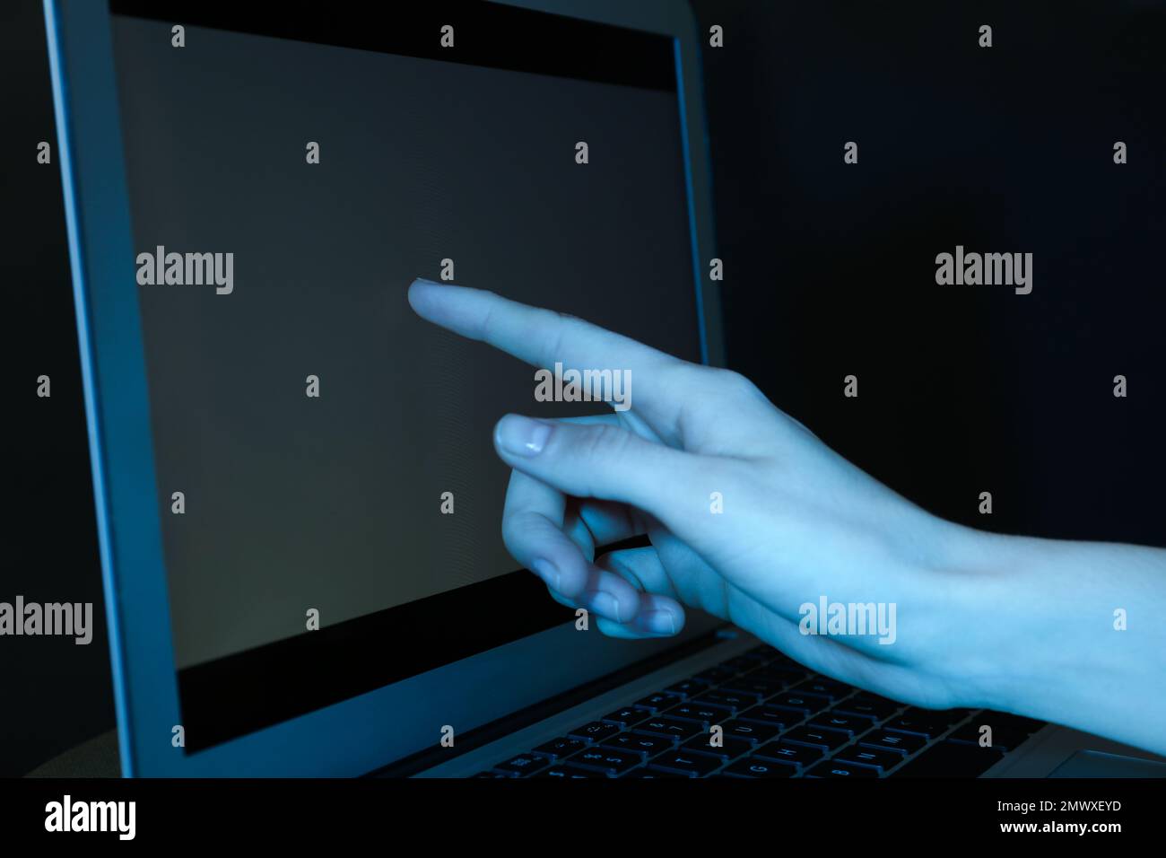 Frau, die den Laptop im dunklen Hintergrund benutzt, Nahaufnahme Stockfoto