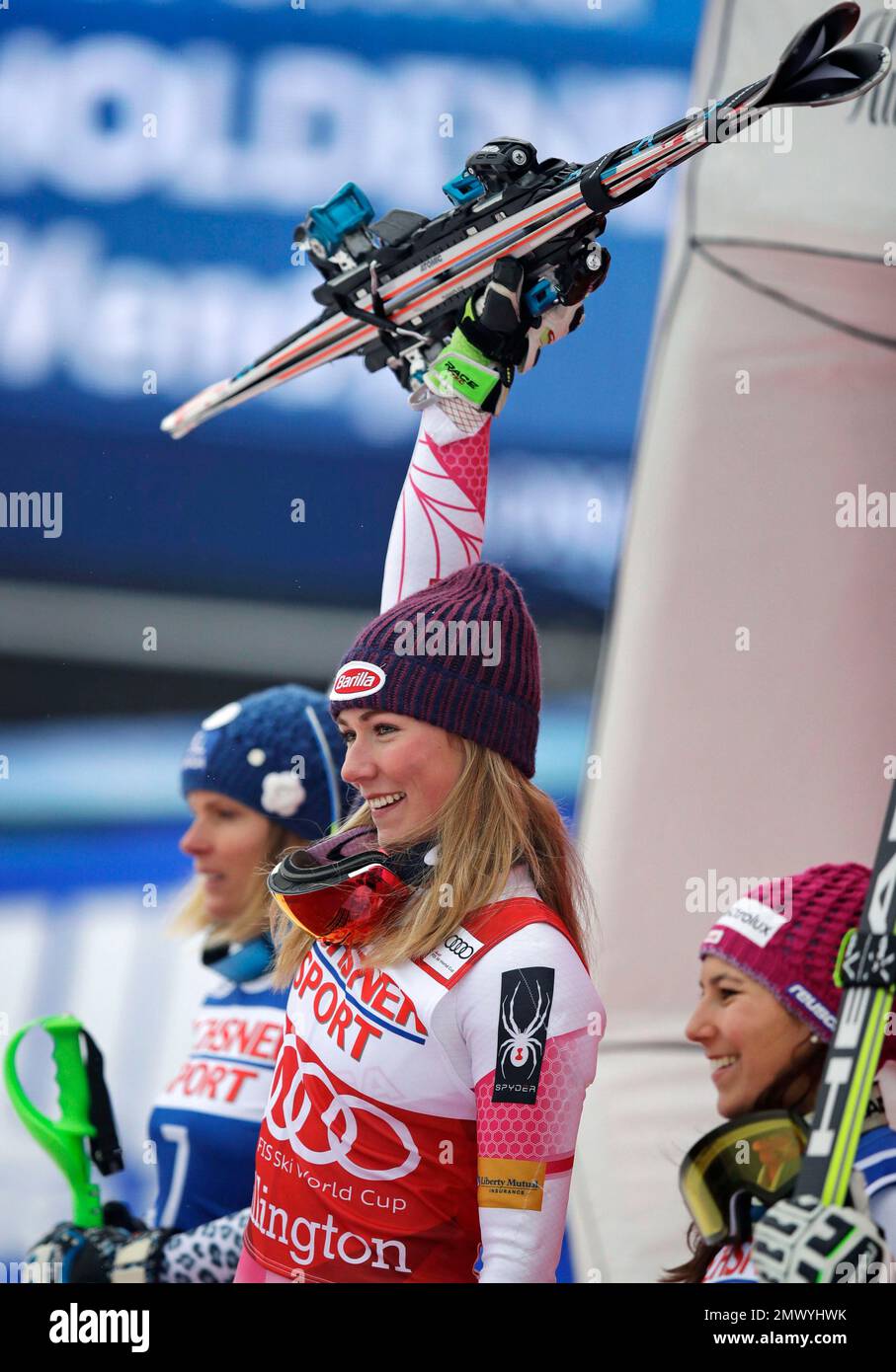 Mikaela Shiffrin, of the United States, center, raises her skis as she
