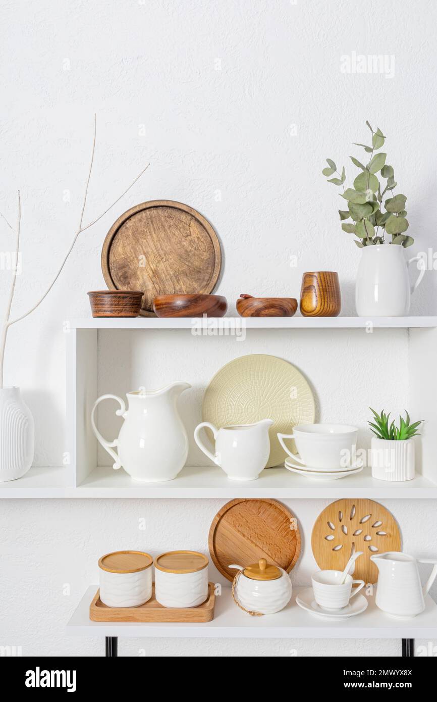 Schöne vertikale Vorderansicht der weißen offenen Holzregale mit Schalen aus umweltfreundlichen Materialien. Das Konzept eines sauberen Hauses ohne Abfall Stockfoto