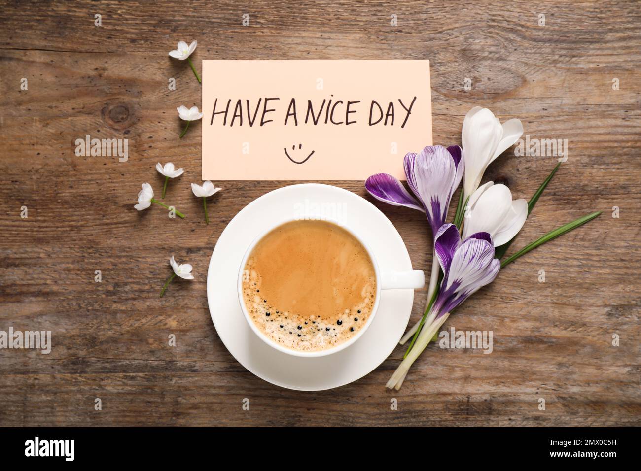 Morgenkaffee, Blumen und Karte mit EINEM SCHÖNEN TAGESWUNSCH auf einem Holztisch, flach liegend Stockfoto