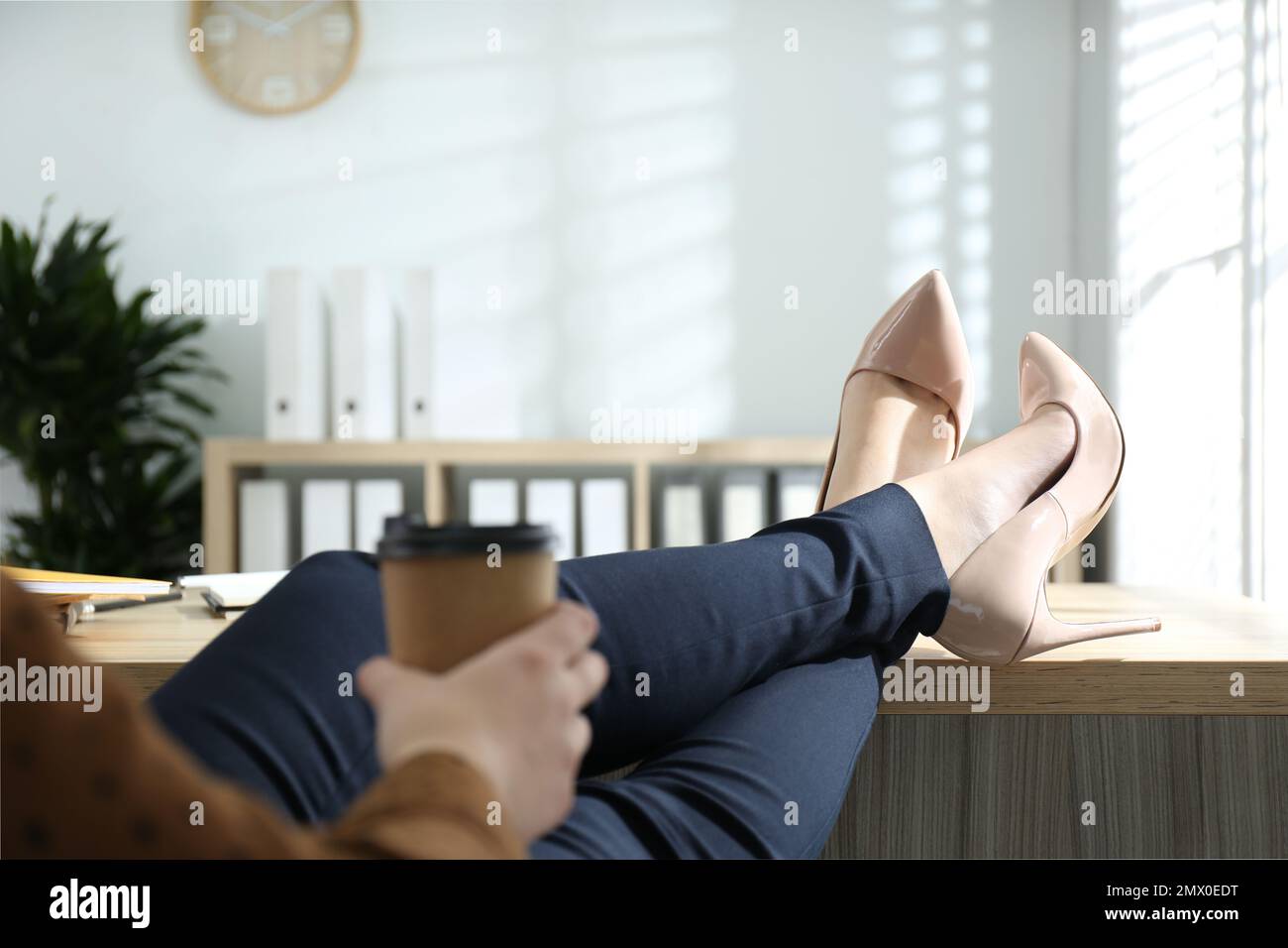 Fauler Arbeiter mit Füßen auf dem Schreibtisch im Büro, Nahaufnahme Stockfoto