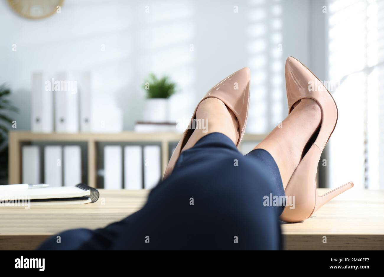 Fauler Arbeiter mit Füßen auf dem Schreibtisch im Büro, Nahaufnahme Stockfoto
