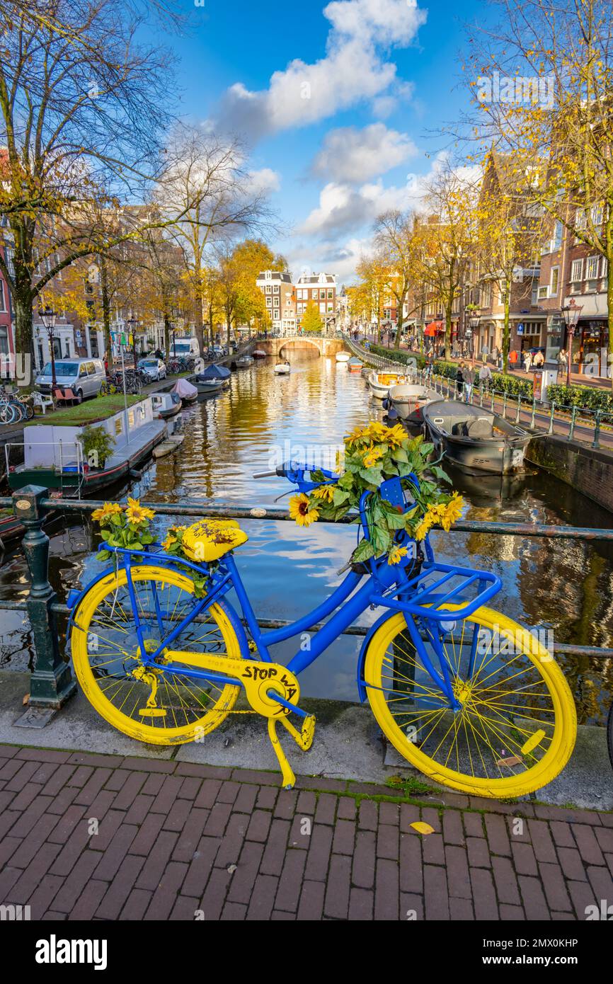 „Steh mit der Ukraine“ blaues und gelbes Fahrrad auf einer Brücke über den Spiegelgacht-Kanal Amsterdam Stockfoto