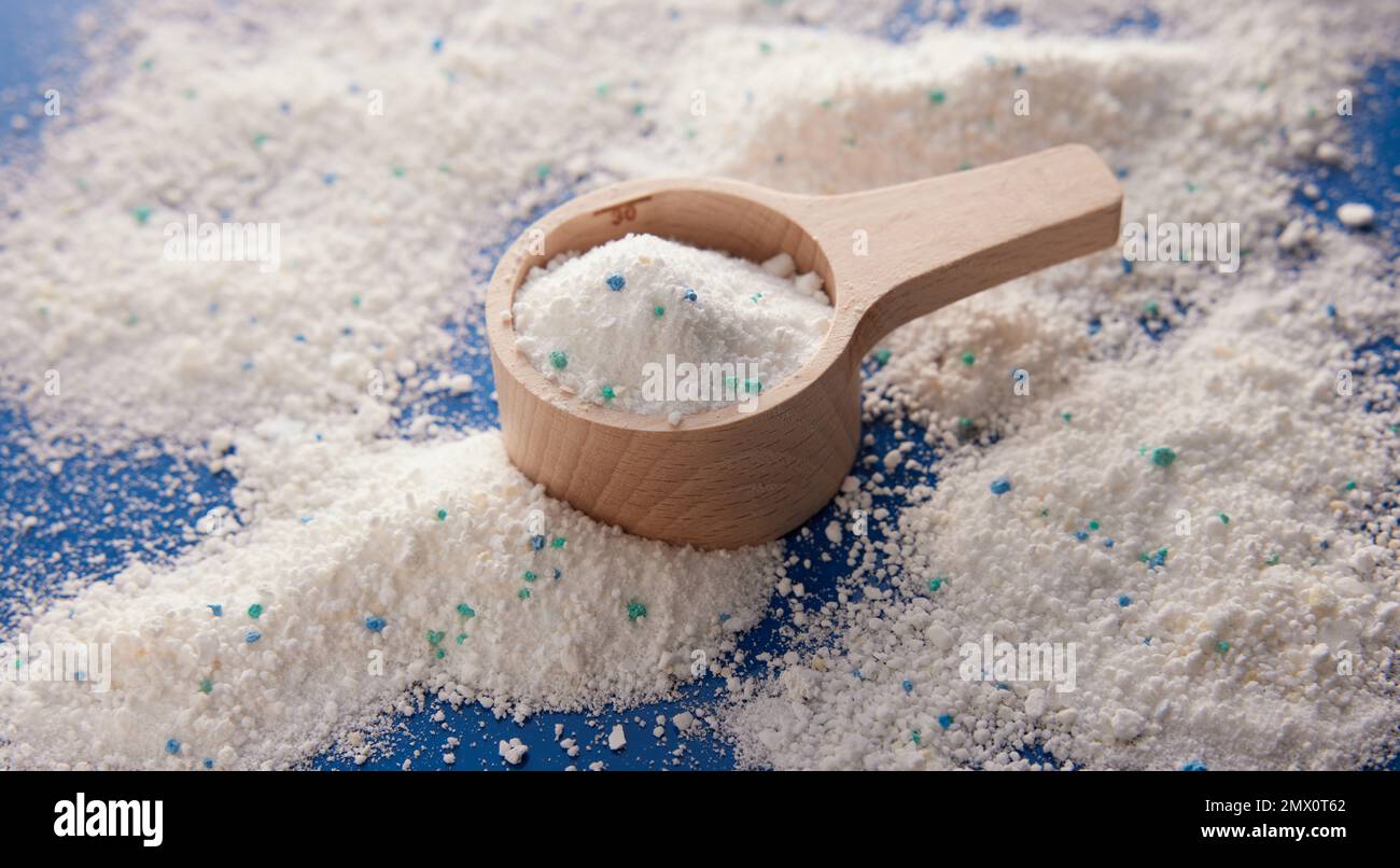 Von oben weißes Waschpulver für die tägliche Hygiene in einem hölzernen Messbecher, der im hellen Raum auf dem Tisch platziert wird Stockfoto