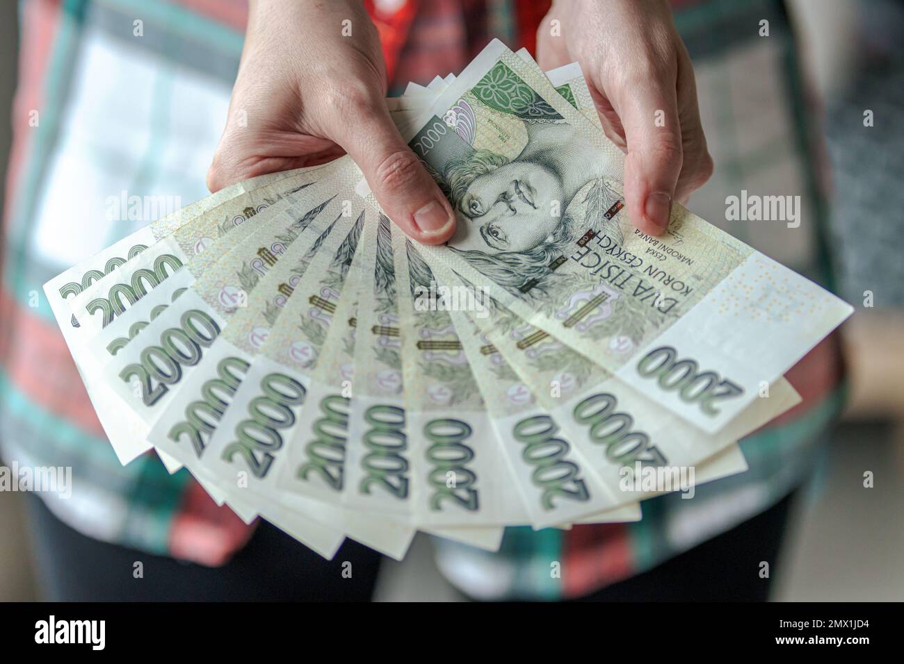 Frau, die zweitausend tschechische Kronen-Banknoten zeigt, in Prag ...
