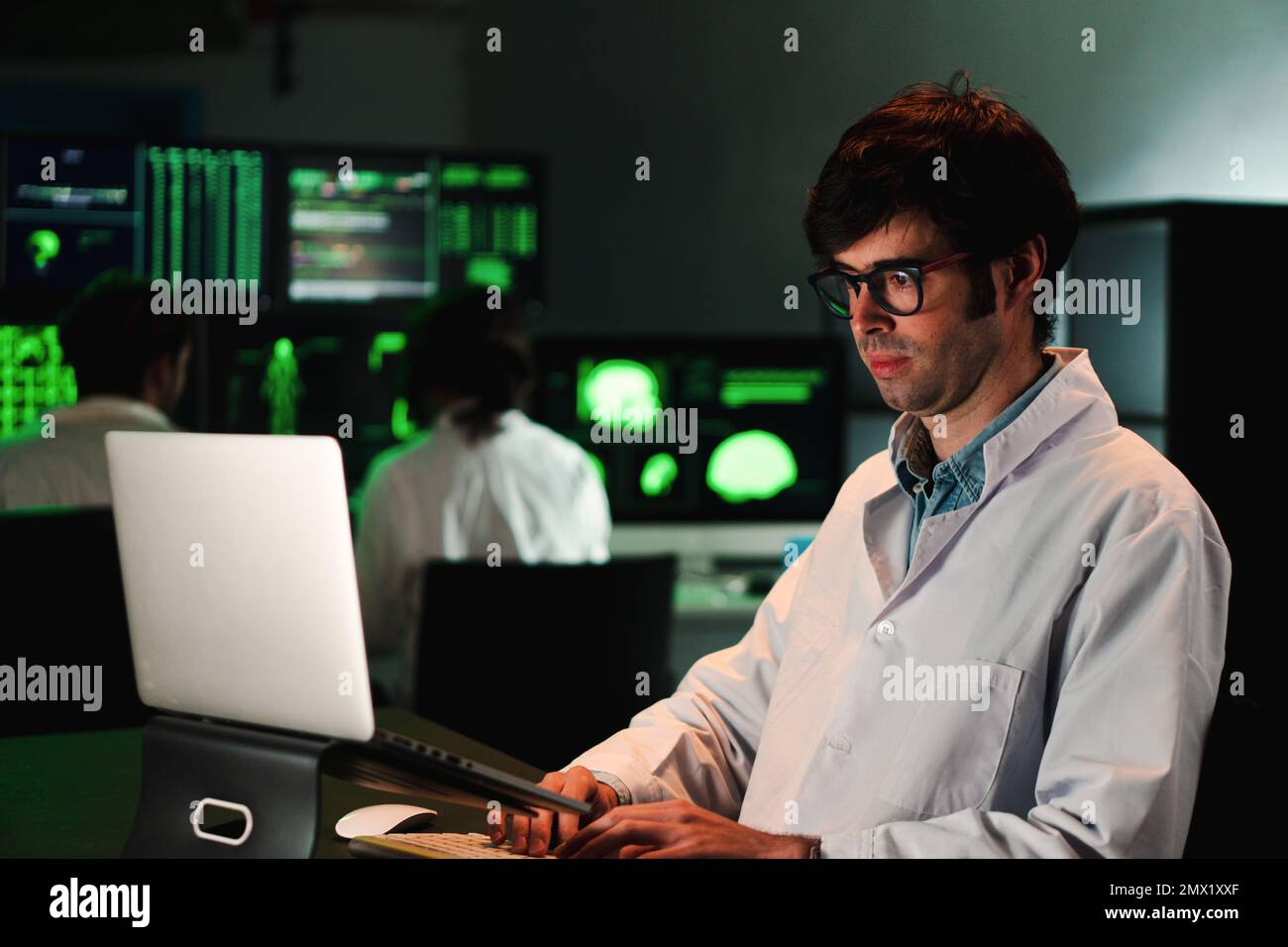 Ein gewisser Biologiewissenschaftler, der arbeitete, konzentrierte sich auf medizinische Analysen in der Pharmazie mit einem Laptop, der einen Laborkittel und eine Schutzbrille trug. Hochwertiges Foto Stockfoto